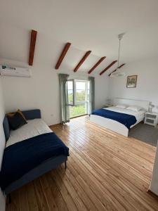 - une chambre avec 2 lits et du parquet dans l'établissement Matisse Residence, à Nerezine