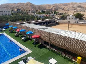 uma vista sobre uma piscina com guarda-sóis e cadeiras em فندق وادي القلط em Jericó