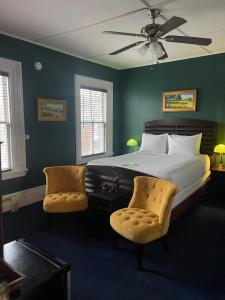 a bedroom with a large bed and two chairs at Somerset House Inn in Provincetown