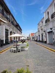 Une rue vide avec des tables et des parasols dans une ville dans l'établissement Inka Roots Hostel, à Arequipa