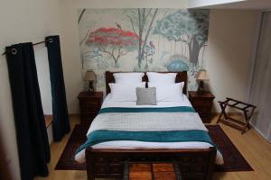 a bedroom with a bed with a painting on the wall at Le Clos de la Challangette in Beaune