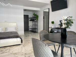 a bedroom with a table and chairs and a bed at Eva Del Mar - Sea view - Parcare Privata Inclusa in Mamaia