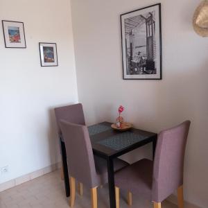 een eettafel en stoelen in een kamer bij appartement vue mer piscines parking LES CORAUX AGAY PLAGE in Agay - Saint Raphael