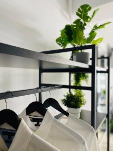 uno scaffale con camicie bianche e piante in una stanza di Eva Del Mar - Sea view - Mamaia Nord a Mamaia