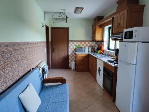 uma cozinha com um sofá azul e um frigorífico branco em Casa Sulo Alombada em Águeda