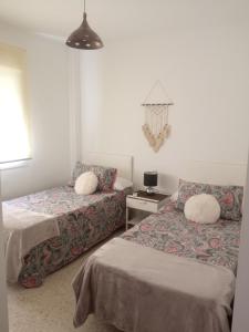 - une chambre avec deux lits et une table avec une lampe dans l'établissement Casa Luz y Azahar, à San Juan del Puerto