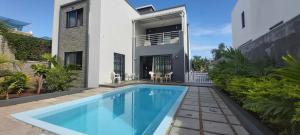 a villa with a swimming pool in front of a house at Beautiful House with private pool in Mauritius in Albion