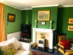 a living room with green walls and a fireplace at Spacious Georgian Apartment, Central Barnard Castle. in Barnard Castle