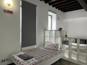 1 dormitorio con 1 cama en una habitación blanca en Loft Matteotti - Studio in centro, en Busto Arsizio