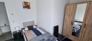 een kleine slaapkamer met een bed en een houten kast bij Ferienwohnung Sheni in Bad Säckingen