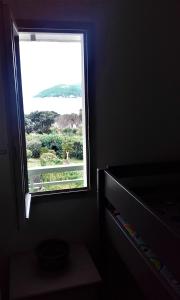 een raam in een kamer met uitzicht op de oceaan bij appartement vue mer piscines parking LES CORAUX AGAY PLAGE in Agay - Saint Raphael