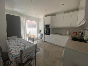 a kitchen with white cabinets and a table and a counter top at Guest House in Faro