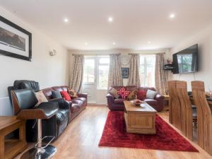 ein Wohnzimmer mit Sofas und einem Tisch in der Unterkunft Pass the Keys Spacious Cosy Home Close To London Abbey Wood in London