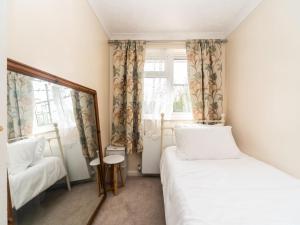 a small room with two beds and a mirror at Pass the Keys Spacious Cosy Home Close To London Abbey Wood in London