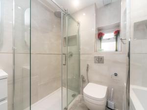 a bathroom with a toilet and a glass shower at Pass the Keys Spacious Cosy Home Close To London Abbey Wood in London