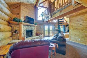 a living room with leather furniture and a stone fireplace at Smoky Mountain Vacation Rental with Hot Tub! in Gatlinburg