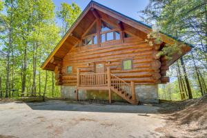 a log cabin in the woods with a large porch at Smoky Mountain Vacation Rental with Hot Tub! in Gatlinburg
