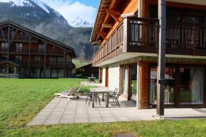 patio ze stołem i krzesłami przed budynkiem w obiekcie T3 rez-de-jardin avec fitness, sauna et tennis - village et ski à pied w mieście La Chapelle-dʼAbondance +36 zdjęć