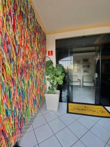 a wall covered in lots of different colored threads at Hostel Da Jô in Ilhéus