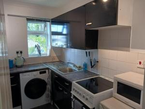 a small kitchen with a sink and a dishwasher at Cosy 1-Bed Apartment in Swindon private parking in Swindon
