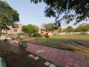 a park with trees and a brick walkway at VRINDA Kunj ASHRAYAM in Vrindāvan