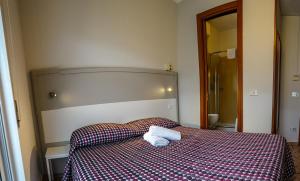 サン・バルトロメーオ・アル・マーレにあるHotel Bellavistaのベッドルーム1室(ベッド1台、タオル2枚付)