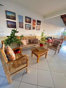 a living room with couches and tables and potted plants at Hostel Da Jô in Ilhéus