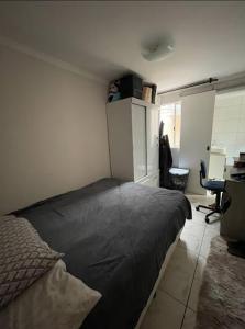 1 dormitorio con 1 cama en una habitación con escritorio en Hostel AJBJ Turismo, en Curitiba