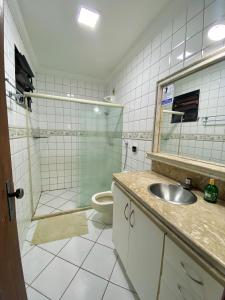 uma casa de banho com um lavatório, um chuveiro e um WC. em Hostel Da Jô em Ilhéus