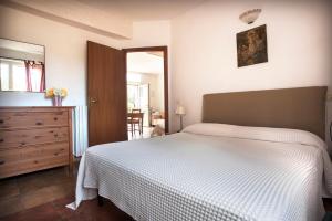 een slaapkamer met een bed, een dressoir en een spiegel bij Cascina Belvedere in Quargnento