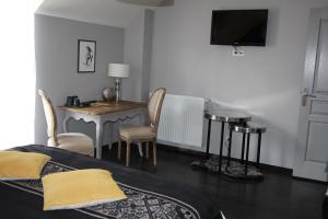 a bedroom with a bed and a table and a desk at Le Clos de la Challangette in Beaune