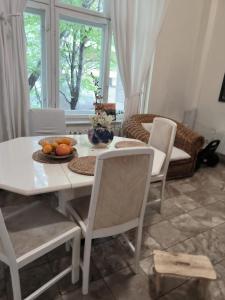 une salle à manger avec une table et des chaises blanches dans l'établissement Unique Villa pe malul lacului Snagov, à Turbaţi