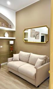 salon z kanapą i lustrem w obiekcie Sikelia Apartment Centro - SELF CHECK-IN w mieście Palermo