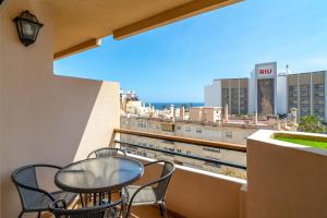 balkon ze stołem i krzesłami oraz widokiem na miasto w obiekcie Cala de Nerja Seaview Casasol w mieście Nerja
