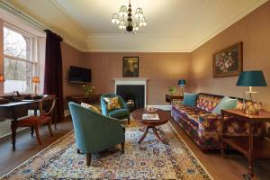 uma sala de estar com um sofá e uma lareira em Cromlix em Kinbuck