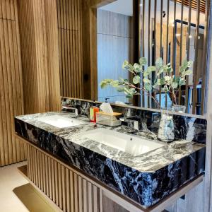 a bathroom with two sinks and a mirror at The Mango Suites by Flat06 in Jakarta
