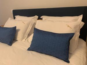 a bed with white pillows and a blue pillow at AL Restaurante A Lampreia in Santa Comba Dão