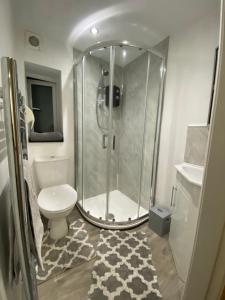 a bathroom with a shower and a toilet and a sink at Park View Cottage in Liversedge