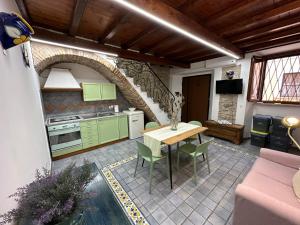 テッラチーナにあるCasa Rappiniのキッチン(緑のキャビネット、テーブル、椅子付)