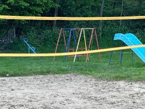 a couple of swings in a playground with yellow tape at Mrežnički doživljaj in Gornji Zvečaj
