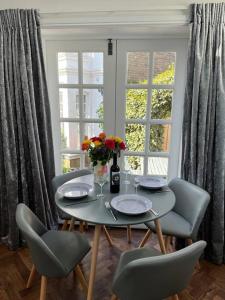 a table with chairs and a vase of flowers on it at Gorgeous Small House in Brighton in Brighton & Hove