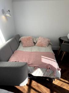a bed with pink pillows on it in a room at Gorgeous Small House in Brighton in Brighton & Hove