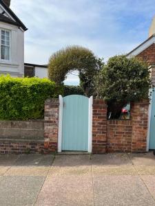 a brick fence with a blue gate in front of a house at Gorgeous Small House in Brighton in Brighton & Hove