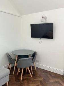 a dining room with a table and chairs and a tv at Gorgeous Small House in Brighton in Brighton & Hove