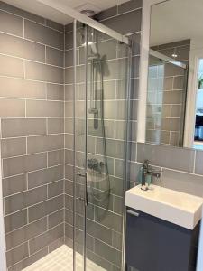 a bathroom with a glass shower and a sink at Gorgeous Small House in Brighton in Brighton & Hove