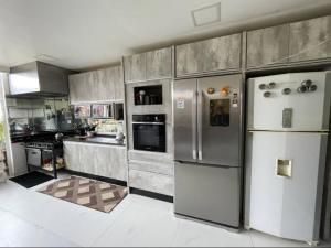 a kitchen with stainless steel refrigerators in a kitchen at Hostel AJBJ Turismo in Curitiba
