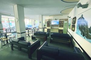 a waiting room with couches and tables and chairs at Hotel Caravan B&B in Pesaro