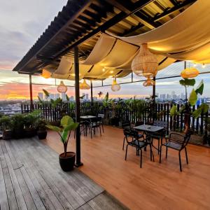 a patio with tables and chairs on a roof at The Mango Suites by Flat06 in Jakarta
