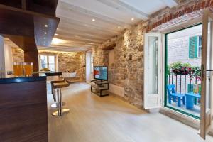 a living room with a stone wall and a television at Luxury San Giovanni Apartment 2 in Split