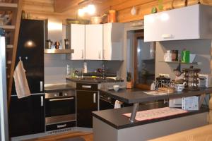 a kitchen with white cabinets and a black counter top at Chata Simon in Nižná Boca